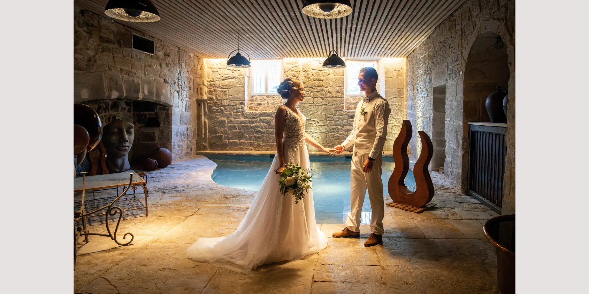 Couple celebrating their wedding by an indoor swimming pool at Chateau d'Aynac
