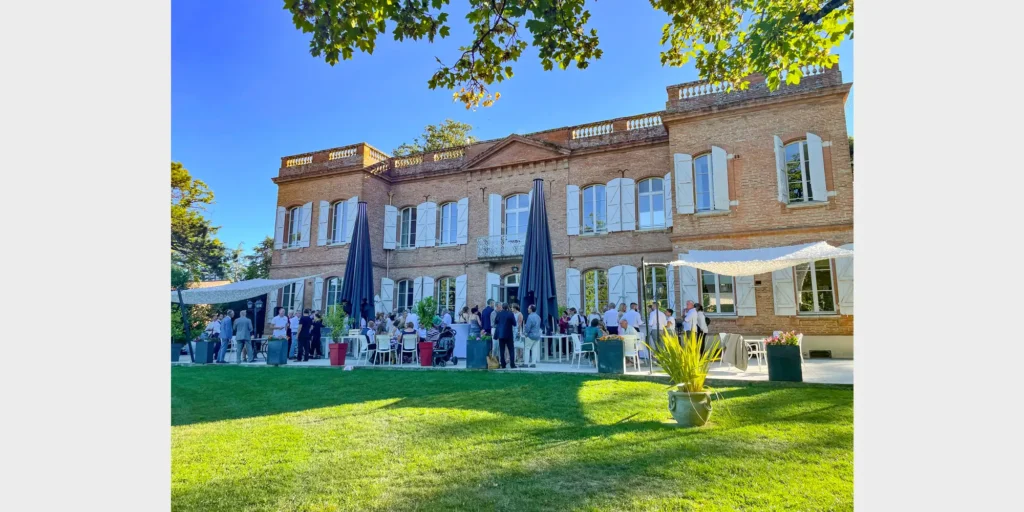 Outdoor cocktail hour in a French chateau garden during a multi-day wedding celebration.