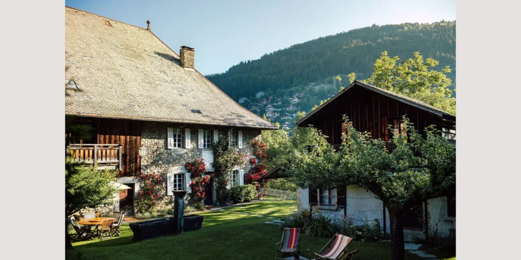 Golden sunlight reflecting off the stone facade of a fairytale wedding venue in the French Alps